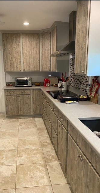 Example of a large l-shaped eat-in kitchen design with an undermount sink, flat-panel cabinets, medium tone wood cabinets, stainless steel appliances and an island