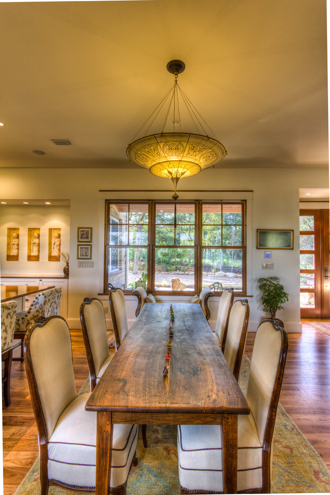 Photo of a mid-sized eclectic open plan dining in Austin with white walls, light hardwood floors and brown floor.