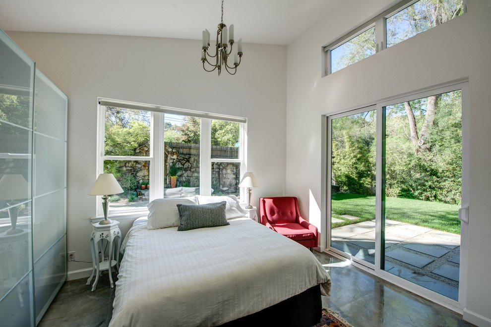 This is an example of a mid-sized contemporary guest bedroom in San Francisco with white walls, concrete floors, no fireplace and grey floor.