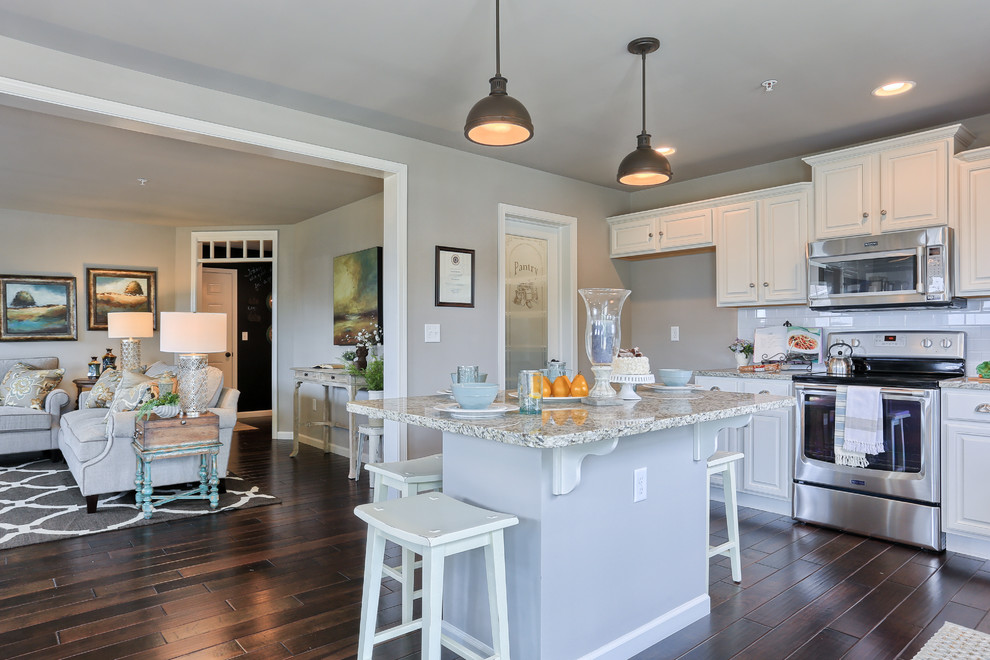 Mid-sized transitional l-shaped dark wood floor and brown floor eat-in kitchen photo with white cabinets, granite countertops, white backsplash, stainless steel appliances and an island