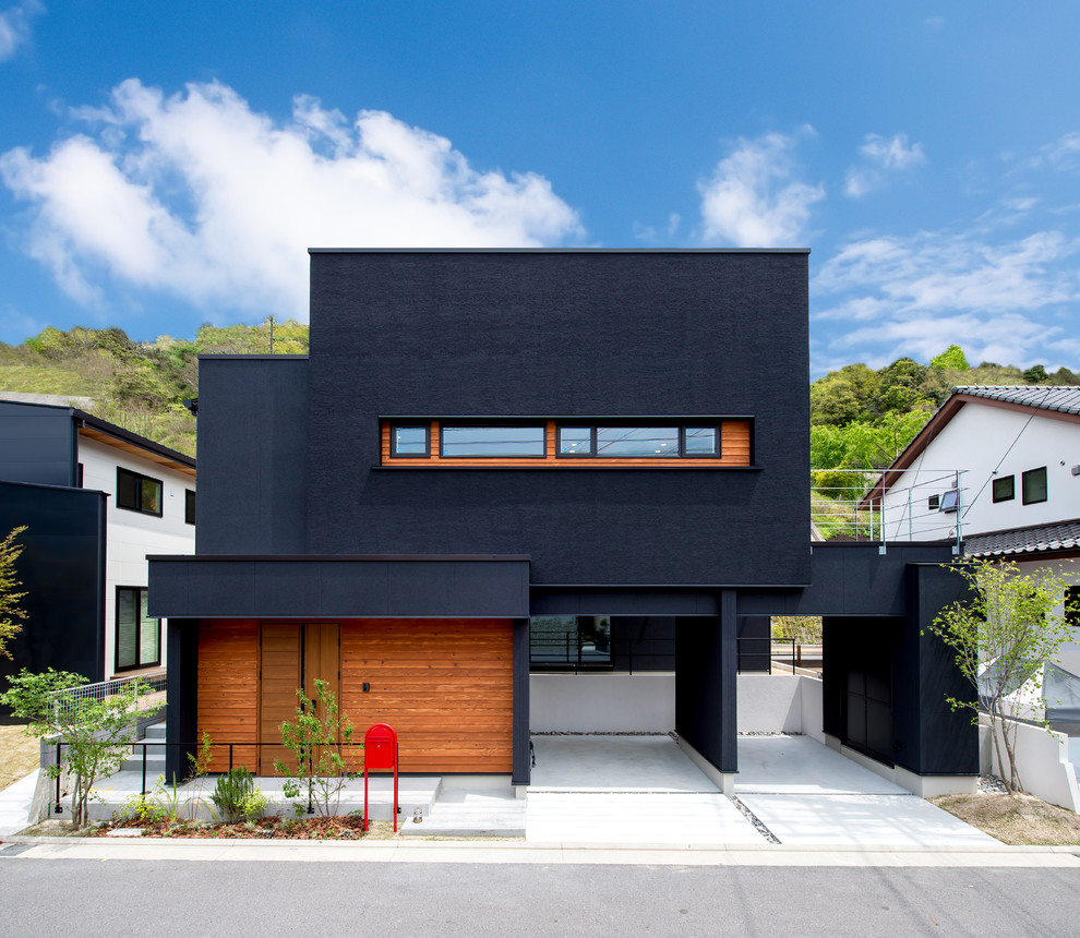 Contemporary two-storey black house exterior in Other with a flat roof.