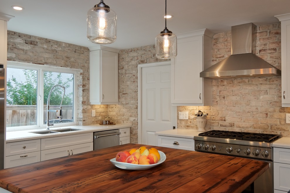 Open concept kitchen - mid-sized rustic l-shaped dark wood floor open concept kitchen idea with an undermount sink, shaker cabinets, white cabinets, quartz countertops, white backsplash, stainless steel appliances, an island and brick backsplash