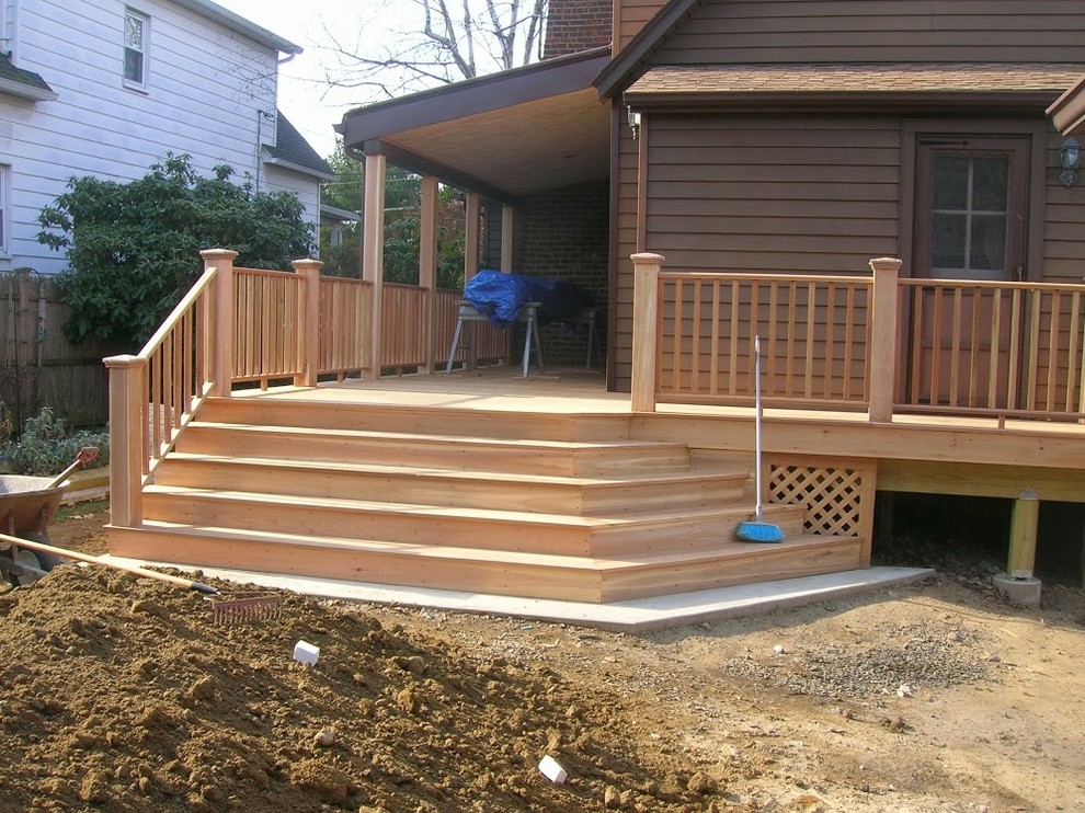 Small traditional backyard deck in New York with a roof extension.