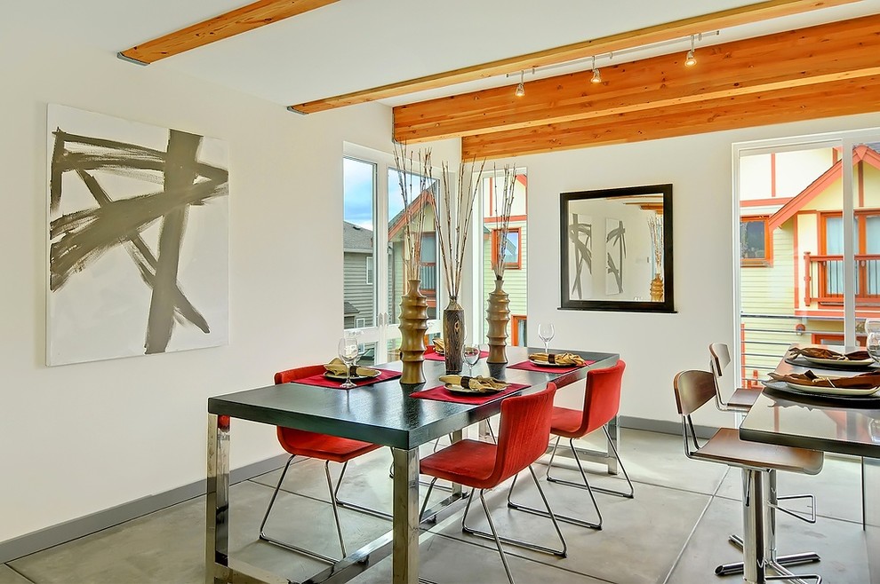 Photo of a contemporary kitchen/dining combo in Seattle with white walls and concrete floors.