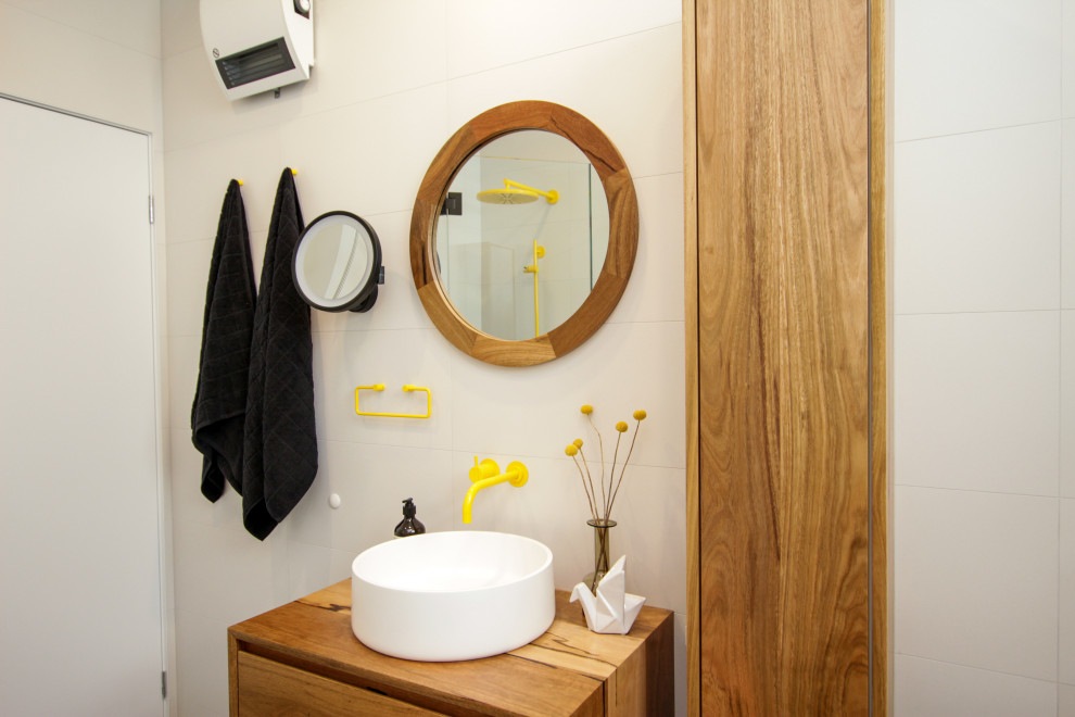 Design ideas for a mid-sized eclectic master bathroom in Sydney with medium wood cabinets, a freestanding tub, a corner shower, a two-piece toilet, white tile, white walls, a vessel sink, grey floor, a hinged shower door, a niche, a single vanity and a floating vanity.