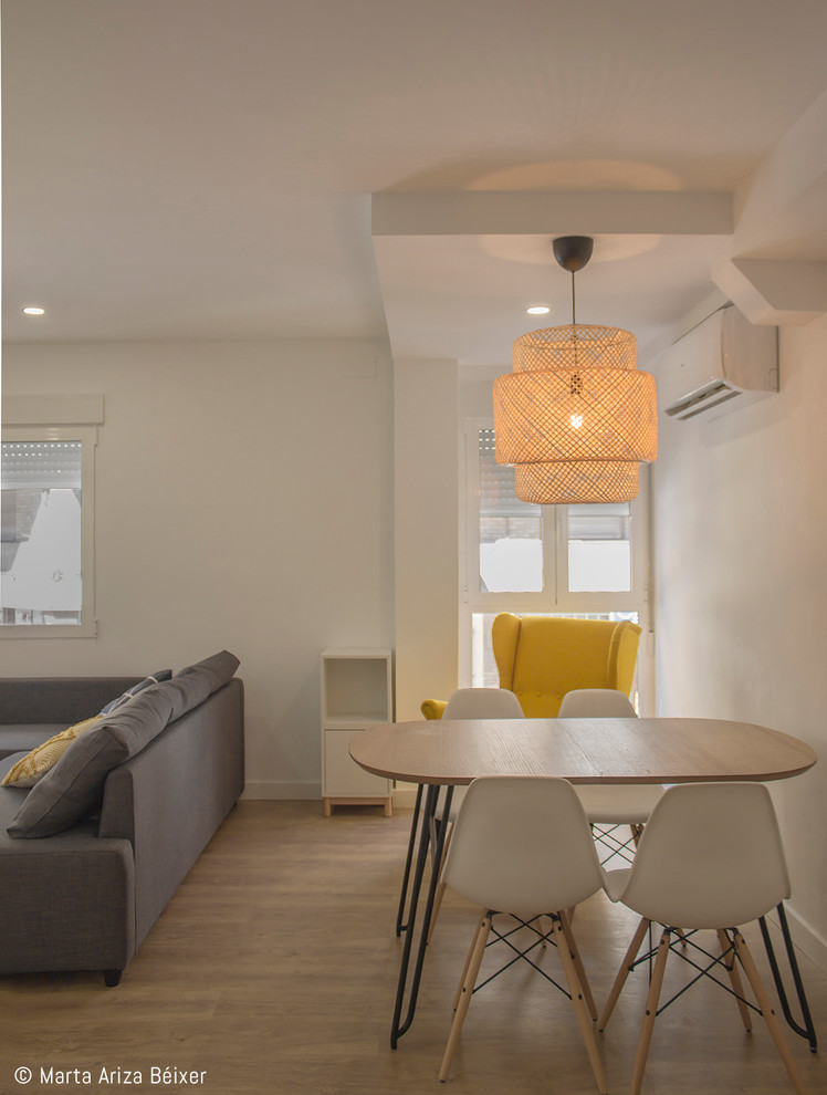 Diseño de comedor nórdico pequeño abierto sin chimenea con paredes blancas, suelo laminado y suelo beige