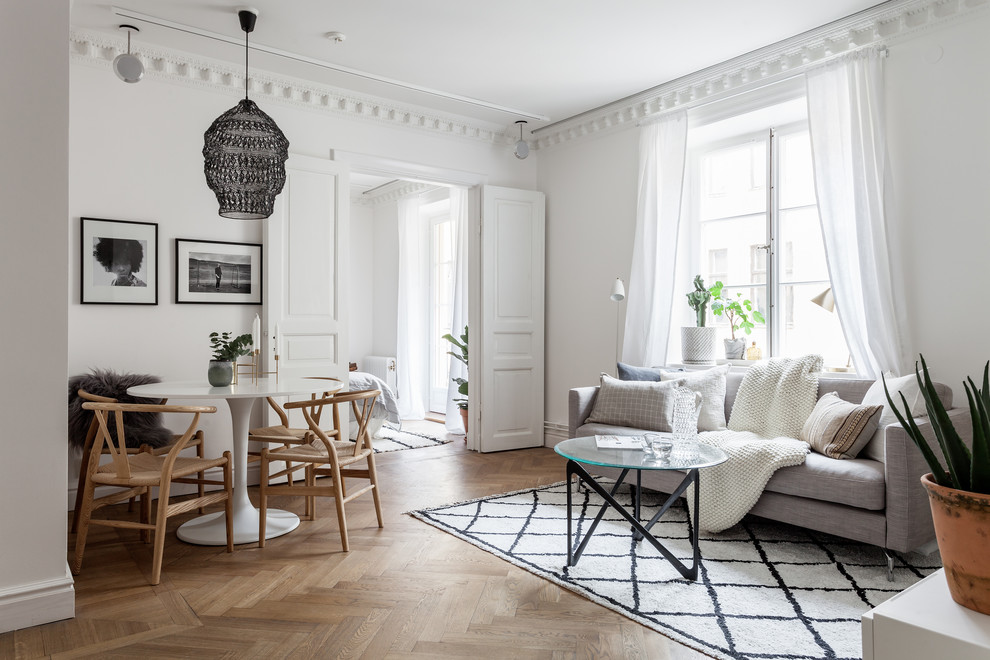 Design ideas for a mid-sized scandinavian formal open concept living room in Stockholm with white walls, light hardwood floors and no tv.