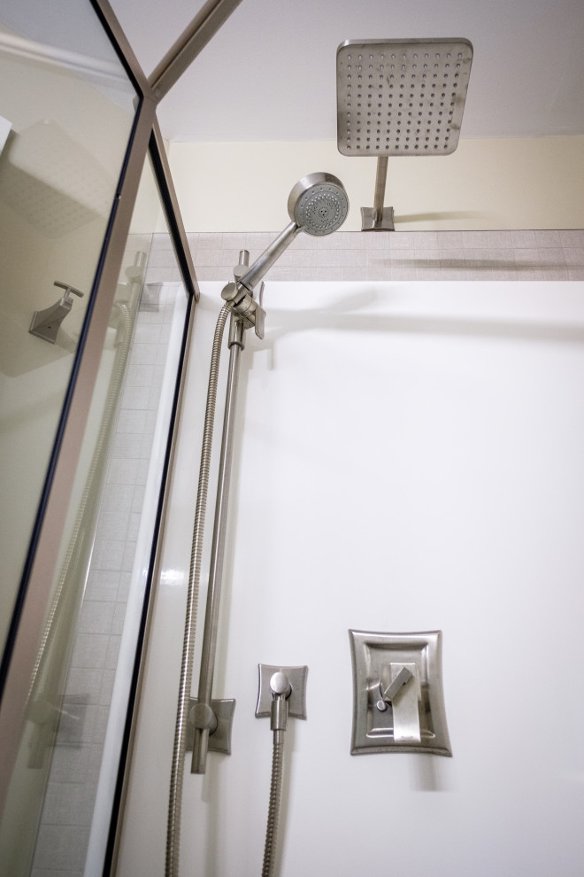 Small transitional 3/4 white tile and ceramic tile ceramic tile, beige floor and single-sink corner shower photo in Edmonton with raised-panel cabinets, beige cabinets, a two-piece toilet, beige walls, an undermount sink, quartz countertops, a hinged shower door, multicolored countertops and a built-in vanity