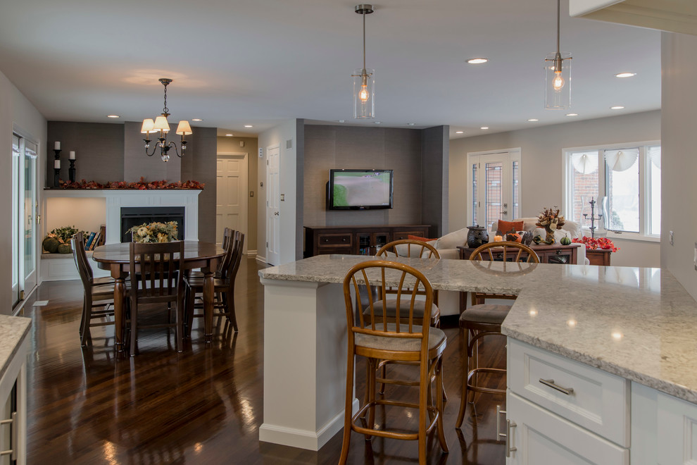 Mid-sized transitional galley medium tone wood floor eat-in kitchen photo in Chicago with an undermount sink, flat-panel cabinets, white cabinets, quartz countertops, beige backsplash, glass tile backsplash, paneled appliances and a peninsula