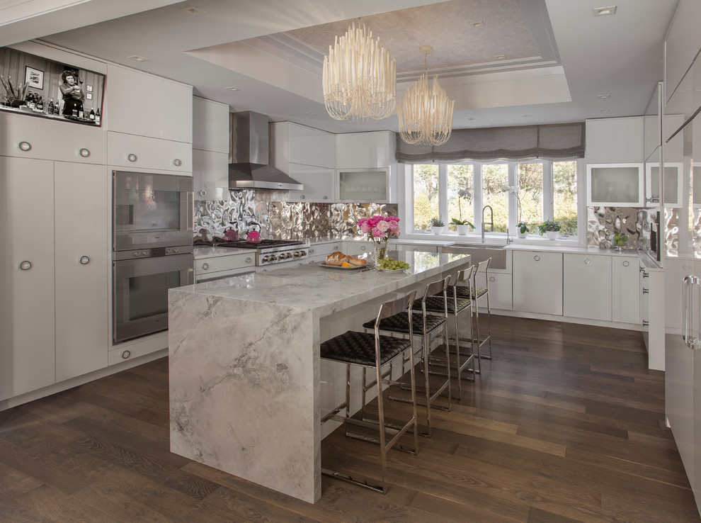 Inspiration for an expansive contemporary u-shaped eat-in kitchen in Boston with a farmhouse sink, flat-panel cabinets, white cabinets, marble benchtops, metallic splashback, metal splashback, stainless steel appliances, medium hardwood floors and with island.
