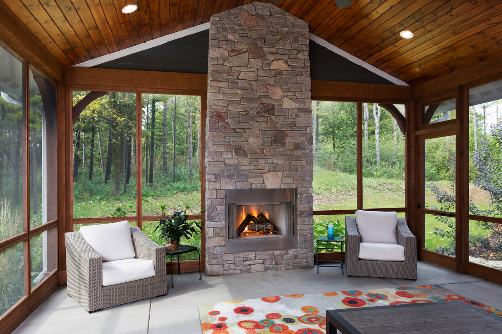 Inspiration for a large arts and crafts sunroom in Milwaukee with a stone fireplace surround, concrete floors, a standard fireplace and grey floor.