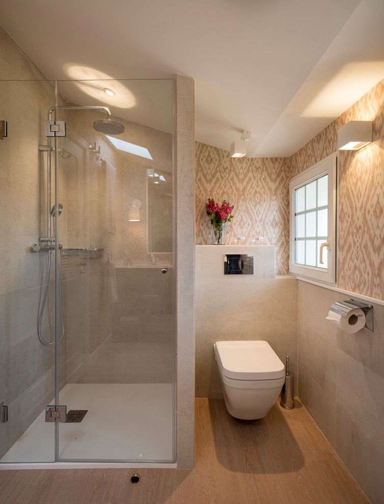 This is an example of a large modern kids bathroom in Bilbao with raised-panel cabinets, grey cabinets, an alcove shower, a wall-mount toilet, beige tile, ceramic tile, beige walls, laminate floors, an undermount sink, engineered quartz benchtops and a hinged shower door.