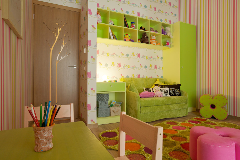 This is an example of a contemporary kids' bedroom for girls with light hardwood flooring.