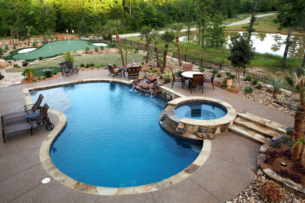 This is an example of a mid-sized arts and crafts backyard pool in New Orleans with a water feature and concrete pavers.