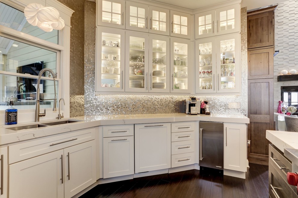 Inspiration for a mid-sized transitional u-shaped eat-in kitchen in Baltimore with an undermount sink, glass-front cabinets, white cabinets, onyx benchtops, metallic splashback, metal splashback, stainless steel appliances, dark hardwood floors, with island, brown floor and white benchtop.