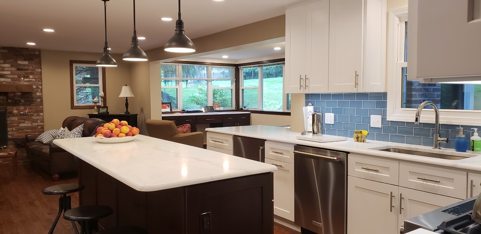 Example of a large transitional u-shaped medium tone wood floor eat-in kitchen design with shaker cabinets, white cabinets, quartzite countertops, blue backsplash, glass tile backsplash, stainless steel appliances, an island and white countertops