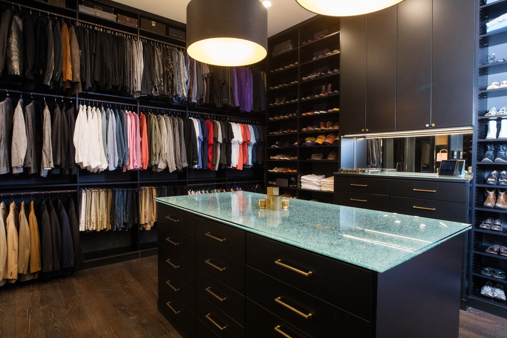 Large modern gender-neutral walk-in wardrobe in New Orleans with flat-panel cabinets, black cabinets, dark hardwood floors and brown floor.
