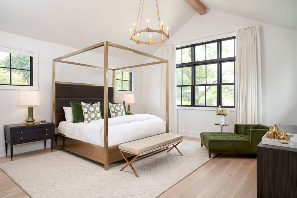 Modelo de dormitorio principal de estilo americano grande con paredes blancas, suelo de madera clara y vigas vistas