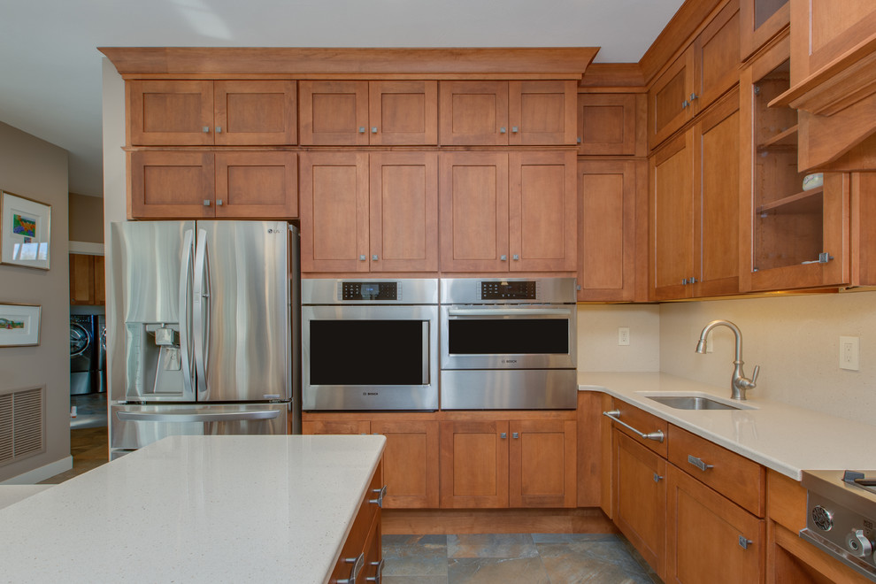 Huge transitional u-shaped open concept kitchen photo in Boston with an undermount sink, shaker cabinets, medium tone wood cabinets, quartz countertops, stone slab backsplash, stainless steel appliances and an island