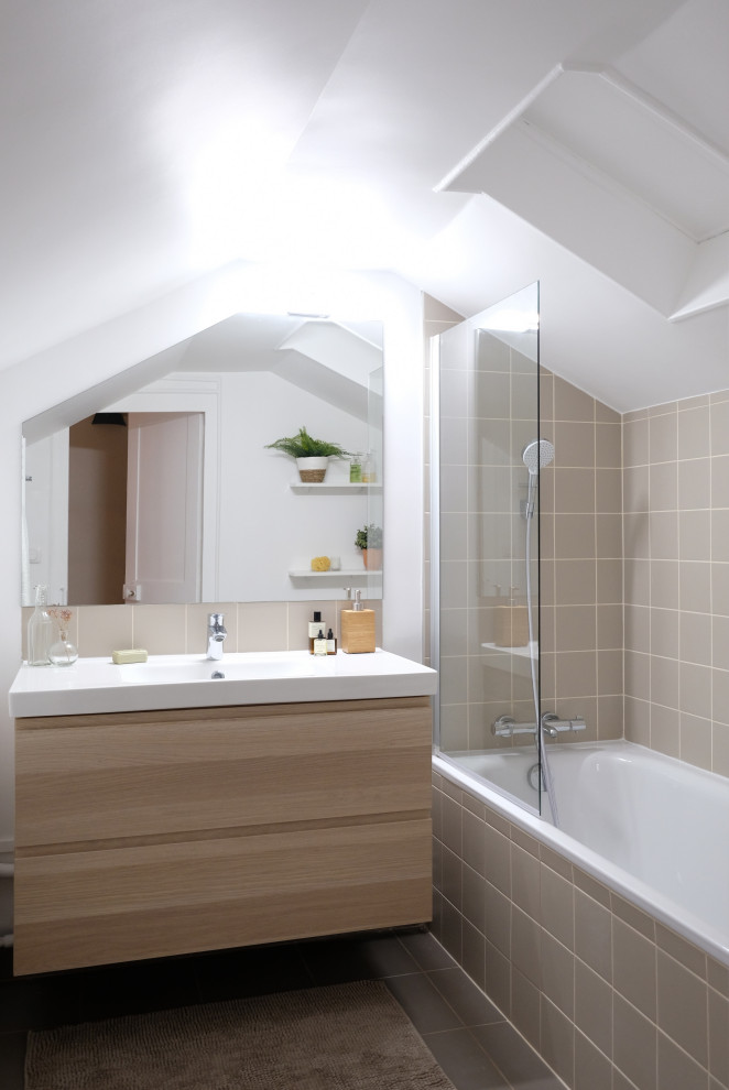 This is an example of a small scandinavian ensuite bathroom with flat-panel cabinets, light wood cabinets, a submerged bath, a shower/bath combination, beige tiles, ceramic tiles, beige walls, ceramic flooring, a console sink, beige floors, white worktops, a single sink and a floating vanity unit.