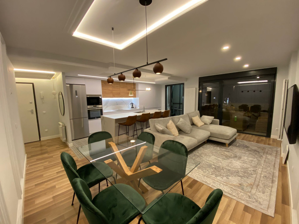 Diseño de comedor actual grande abierto sin chimenea con paredes grises, suelo de madera en tonos medios, suelo multicolor y boiserie