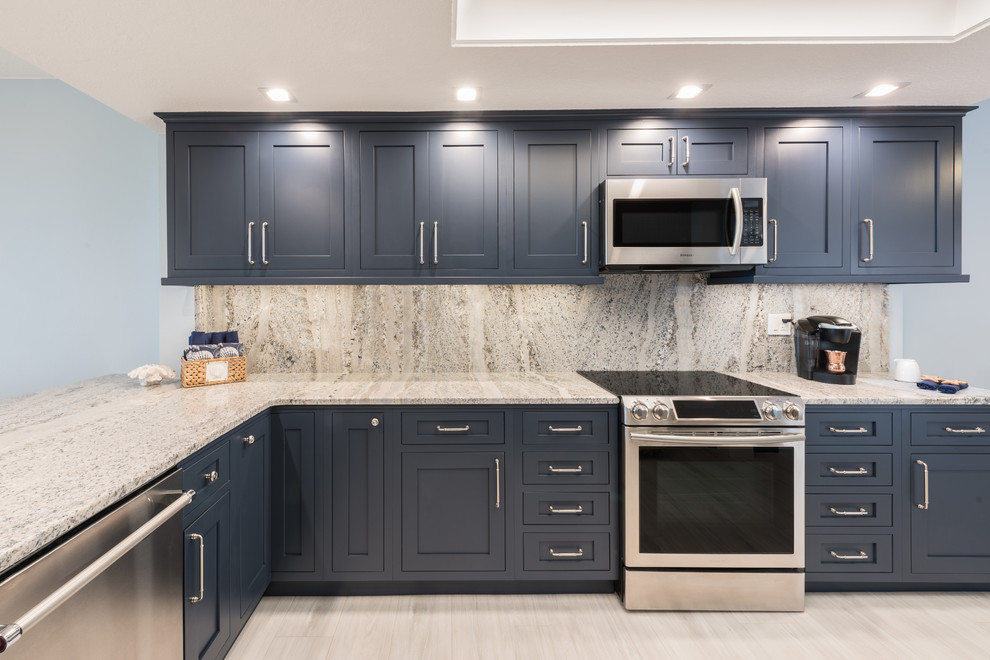 Inspiration for a large transitional l-shaped eat-in kitchen in Orlando with an undermount sink, blue cabinets, granite benchtops, beige splashback, stone slab splashback, stainless steel appliances, porcelain floors, a peninsula, white floor and beige benchtop.