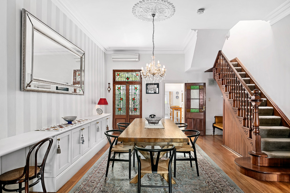 Traditional separate dining room in Sydney with white walls, medium hardwood floors, no fireplace and brown floor.