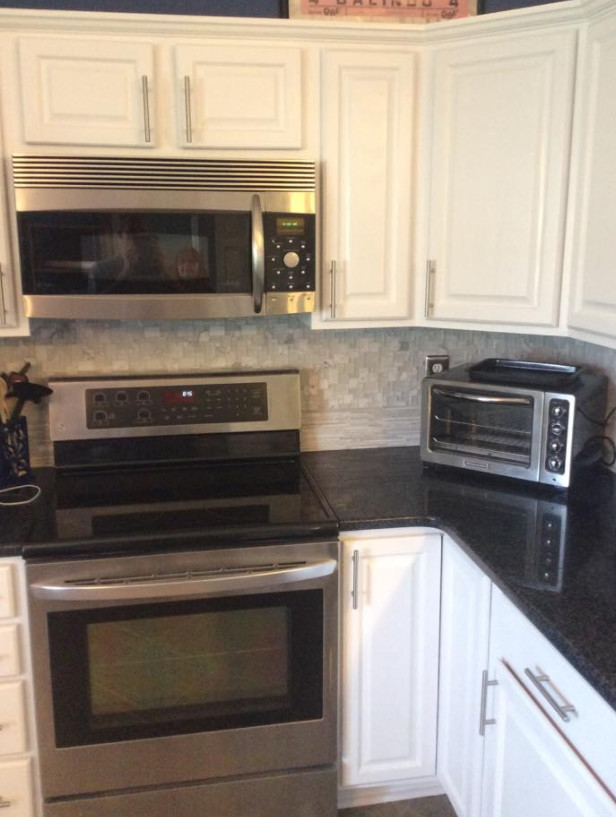 Example of a mid-sized transitional l-shaped eat-in kitchen design in Orlando with raised-panel cabinets, white cabinets, quartz countertops, gray backsplash, mosaic tile backsplash, stainless steel appliances and no island