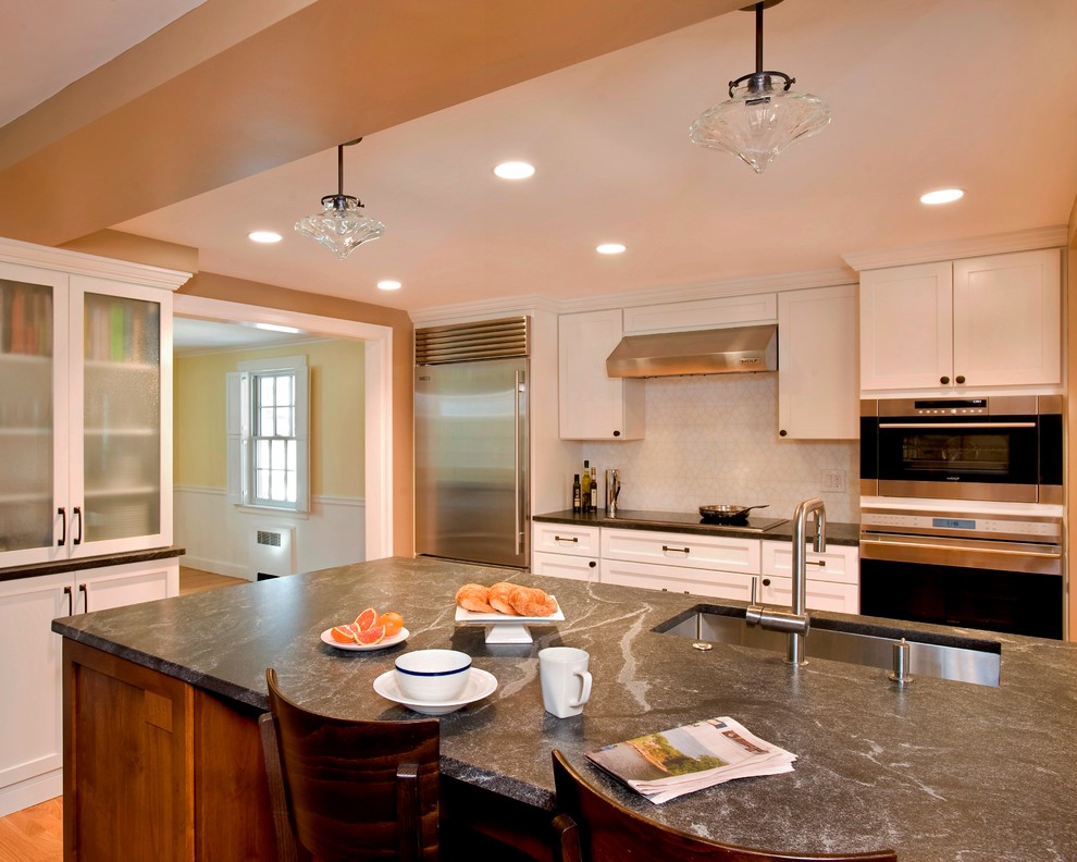 Eat-in kitchen - transitional galley eat-in kitchen idea in Boston with an undermount sink, shaker cabinets, white cabinets, granite countertops, white backsplash and stainless steel appliances