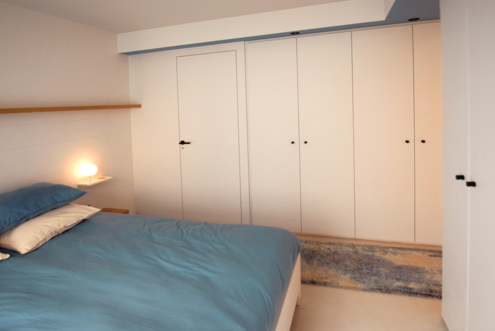Imagen de dormitorio actual de tamaño medio sin chimenea con paredes beige, suelo de cemento y suelo beige