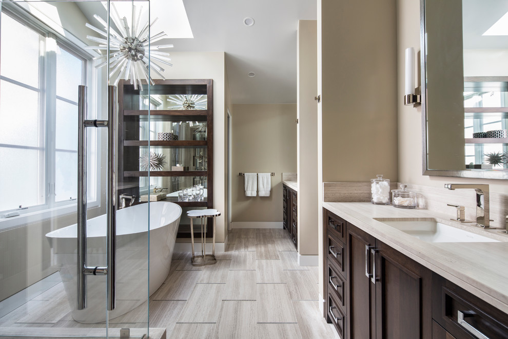 Inspiration for a mid-sized transitional master bathroom in Orange County with a freestanding tub, a corner shower, beige walls, porcelain floors, an undermount sink, beige floor, a hinged shower door, recessed-panel cabinets, dark wood cabinets, beige tile, porcelain tile and beige benchtops.