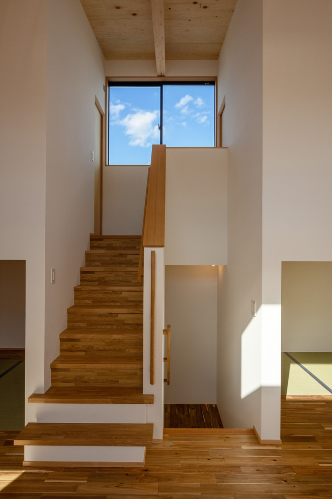 Cette photo montre un petit escalier droit scandinave avec des marches en bois et du papier peint.
