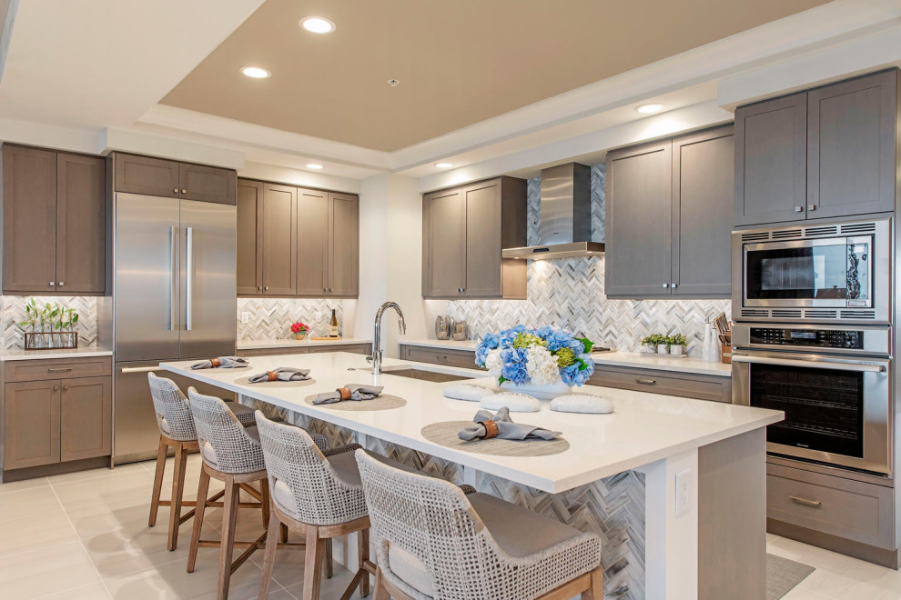 Open concept kitchen - small modern l-shaped ceramic tile, white floor and tray ceiling open concept kitchen idea in Other with an undermount sink, flat-panel cabinets, stainless steel appliances, an island, light wood cabinets, multicolored backsplash and white countertops