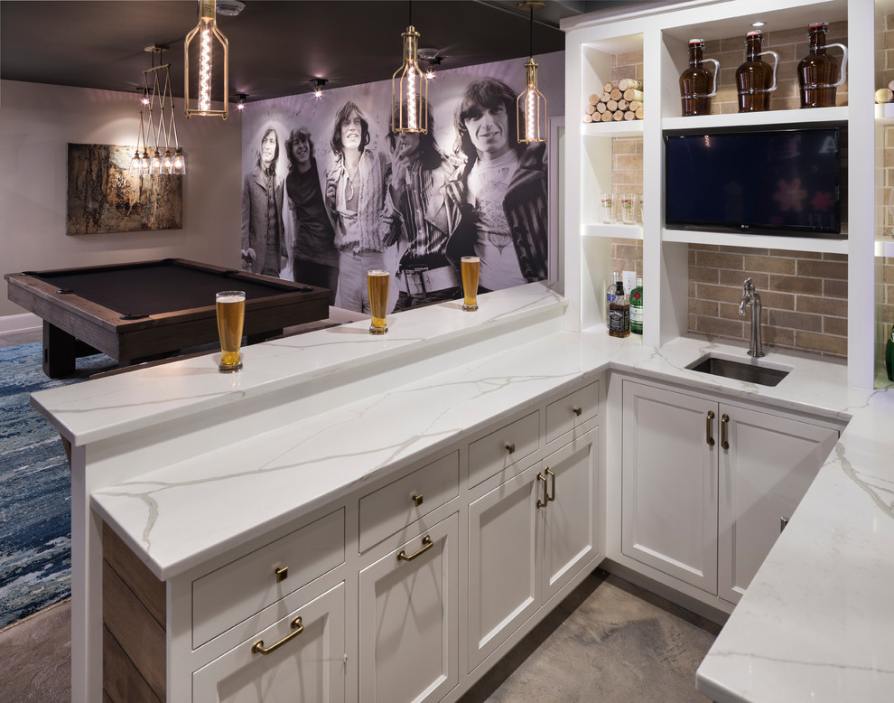 Inspiration for a large industrial u-shaped seated home bar in Minneapolis with an undermount sink, recessed-panel cabinets, white cabinets, marble benchtops, brown splashback, brick splashback and concrete floors.