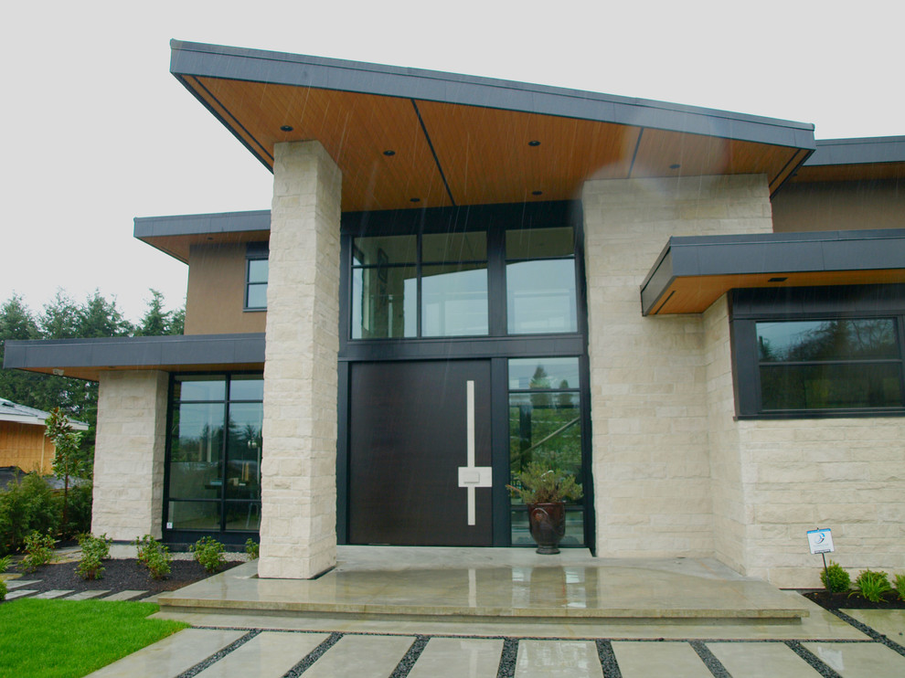 Design ideas for an expansive modern front door in Vancouver with beige walls, concrete floors, a pivot front door and a dark wood front door.