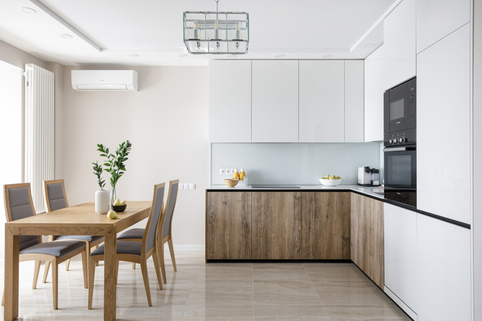 This is an example of a small contemporary l-shaped open plan kitchen in Moscow with a single-bowl sink, white cabinets, solid surface benchtops, white splashback, glass sheet splashback, panelled appliances, no island and white benchtop.