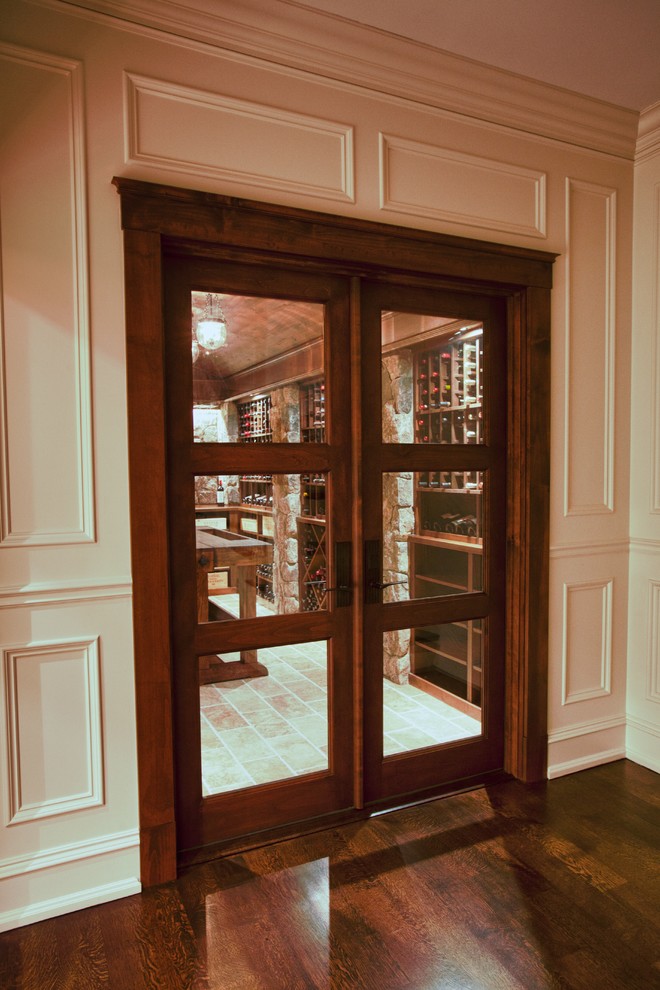 This is an example of a traditional wine cellar in Boston with travertine floors and diamond bins.