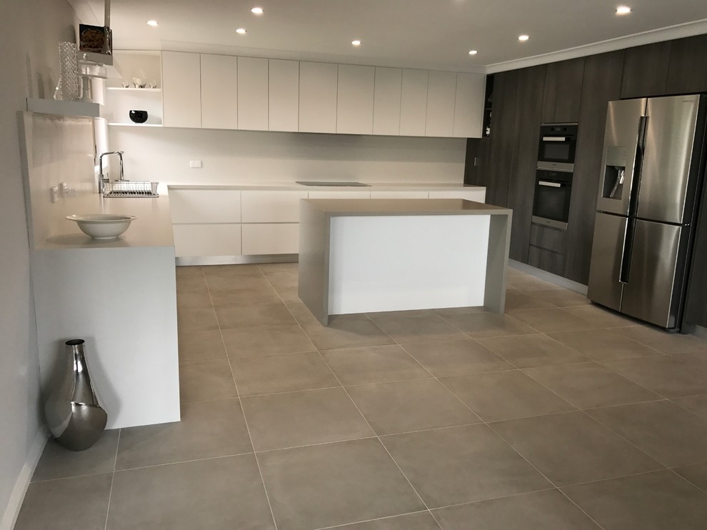 Contemporary open plan kitchen in Melbourne with a double-bowl sink, flat-panel cabinets, white cabinets, quartz benchtops, white splashback, glass sheet splashback, stainless steel appliances, porcelain floors and with island.