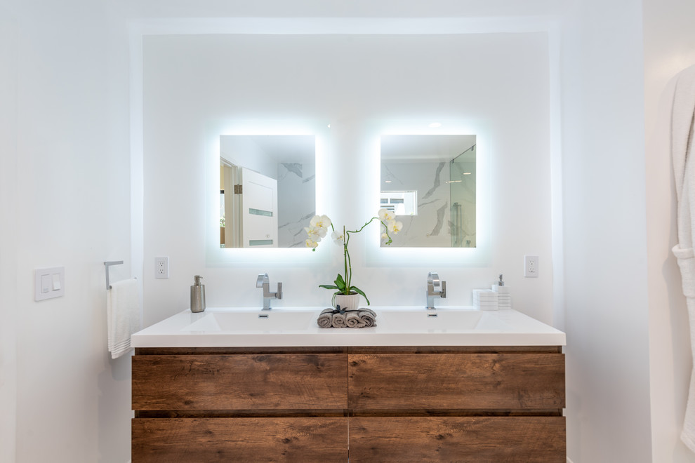 Large trendy master white tile and porcelain tile porcelain tile and white floor freestanding bathtub photo in Los Angeles with flat-panel cabinets, medium tone wood cabinets, white walls, a two-piece toilet, an integrated sink, quartz countertops, a hinged shower door and white countertops