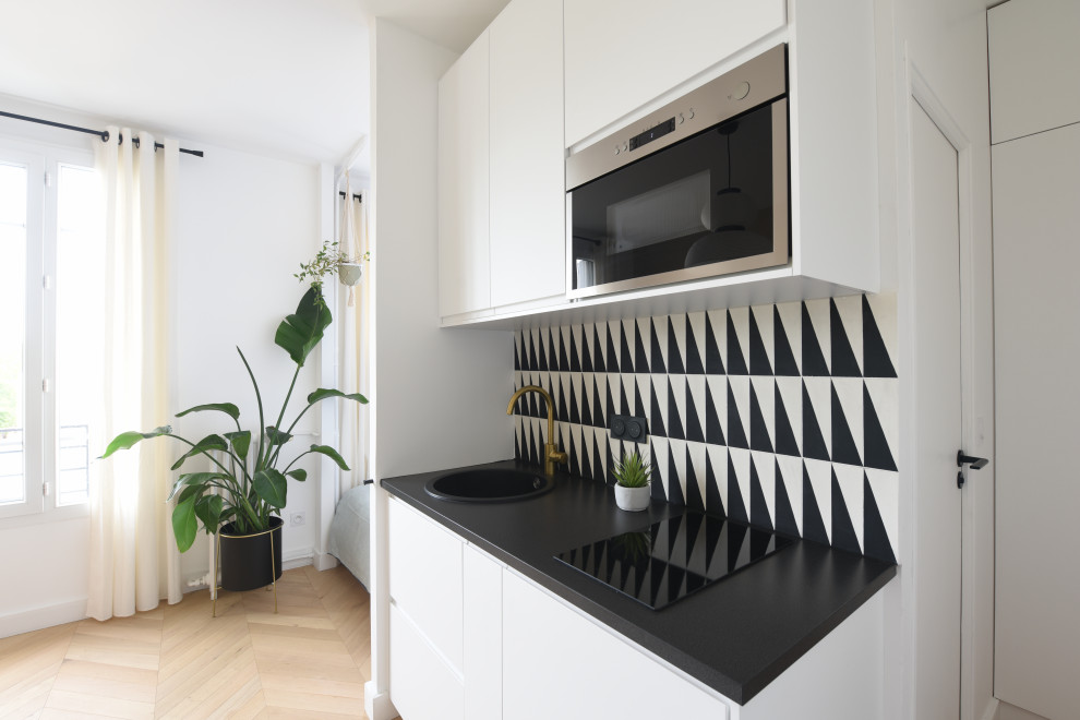 Einzeilige, Kleine Moderne Küche ohne Insel mit Waschbecken, Laminat-Arbeitsplatte, bunter Rückwand, Rückwand aus Zementfliesen, Laminat und schwarzer Arbeitsplatte in Paris