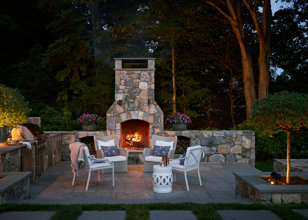 Imagen de patio clásico de tamaño medio en patio trasero con brasero y adoquines de piedra natural