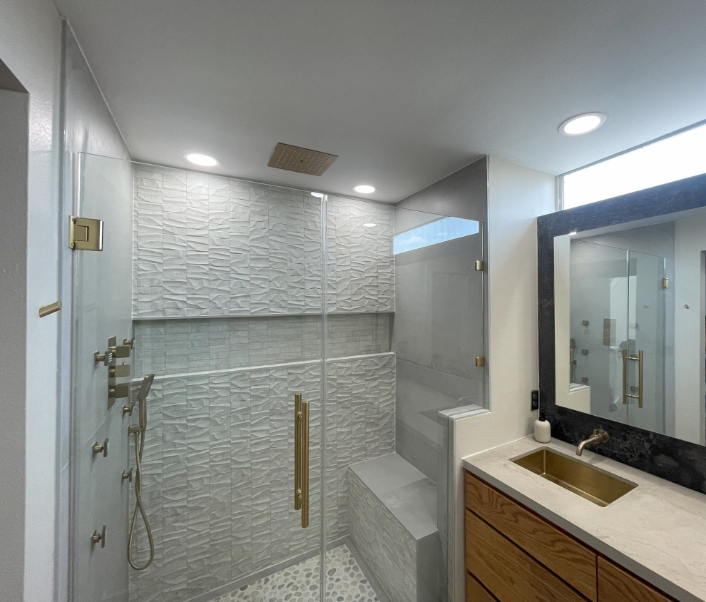 Idéer för mellanstora vitt en-suite badrum, med skåp i ljust trä, ett fristående badkar, grå kakel, porslinskakel, ett nedsänkt handfat, grått golv och släta luckor
