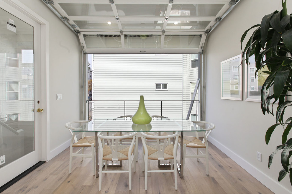 Photo of a mid-sized contemporary dining room in San Francisco with grey walls and light hardwood floors.
