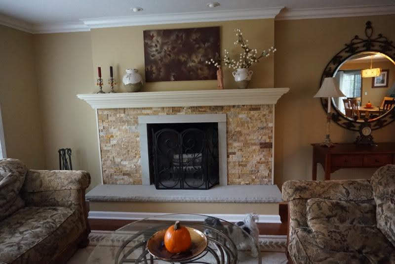 This is an example of a transitional family room in Cleveland with yellow walls, bamboo floors, a standard fireplace, a stone fireplace surround and brown floor.