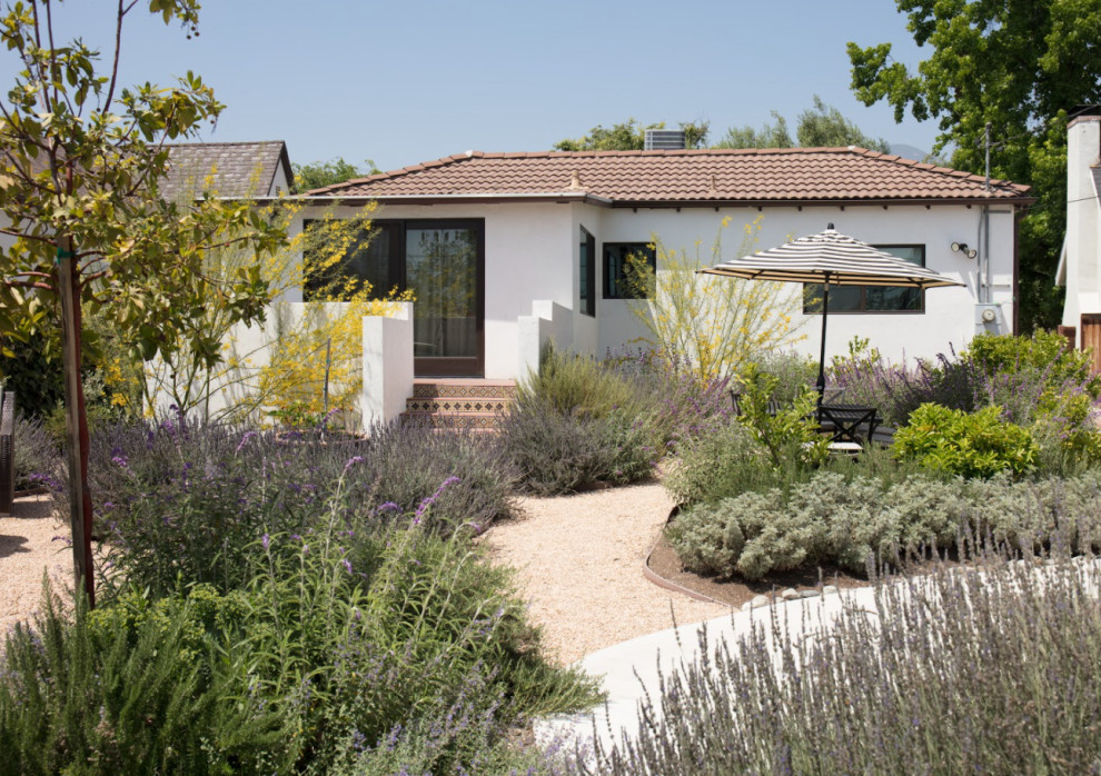 Large mediterranean back xeriscape full sun garden for summer in Los Angeles with a flowerbed and gravel.