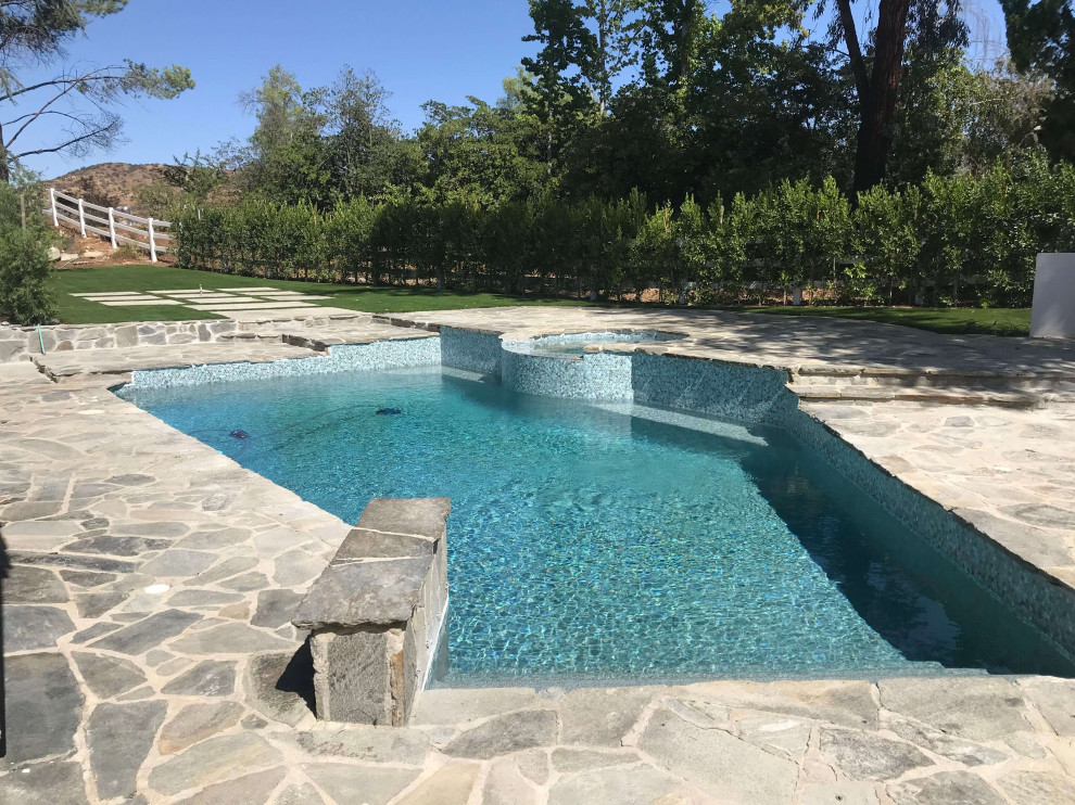 Inspiration for a mid-sized backyard stone and custom-shaped natural hot tub remodel