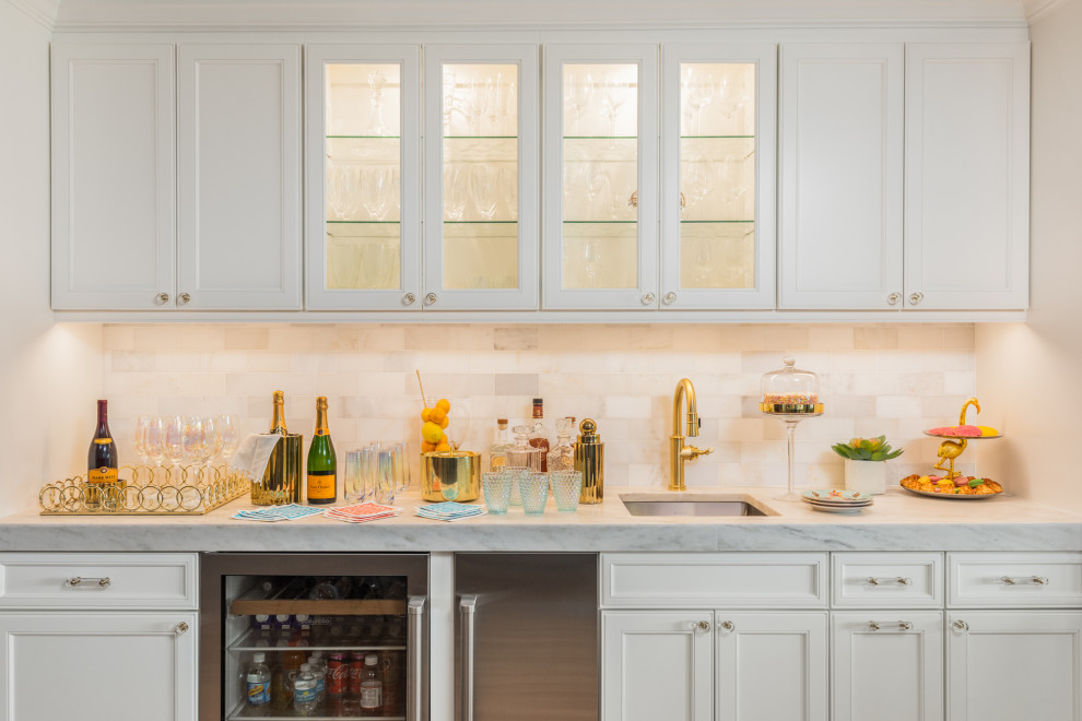 This is an example of a beach style single-wall wet bar in Tampa with an undermount sink, recessed-panel cabinets, white cabinets, white splashback and white benchtop.