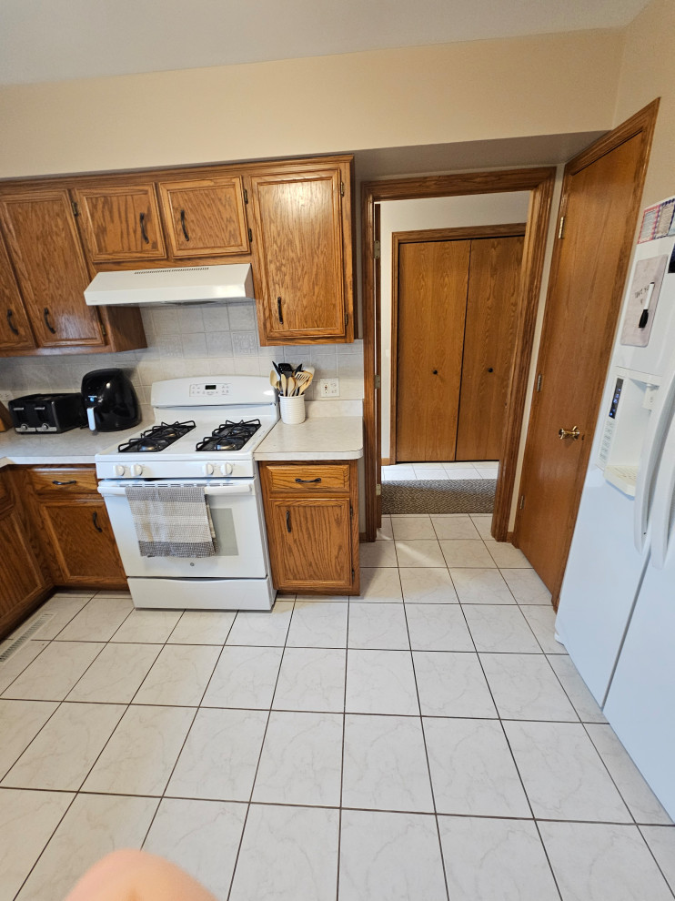 Inspiration for a large transitional u-shaped porcelain tile and white floor eat-in kitchen remodel in Chicago with an undermount sink, shaker cabinets, white cabinets, quartz countertops, brown backsplash, mosaic tile backsplash, stainless steel appliances, a peninsula and multicolored countertops