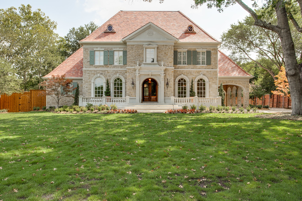 Large transitional three-story stone exterior home idea in Dallas