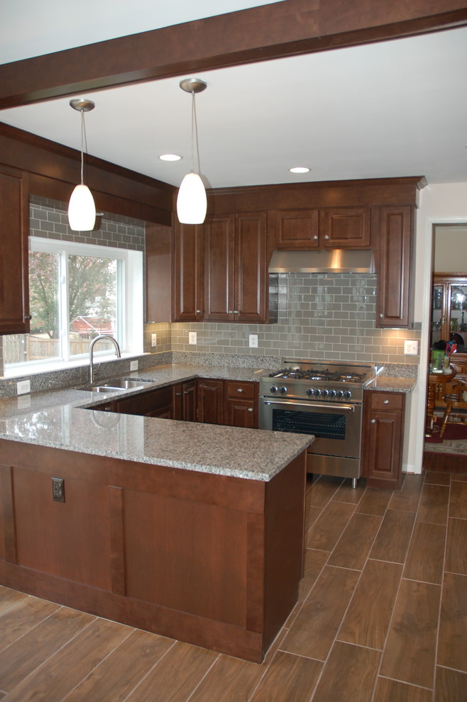 Example of a mid-sized transitional u-shaped plywood floor eat-in kitchen design in DC Metro with an undermount sink, shaker cabinets, dark wood cabinets, granite countertops, gray backsplash, glass tile backsplash, stainless steel appliances and a peninsula